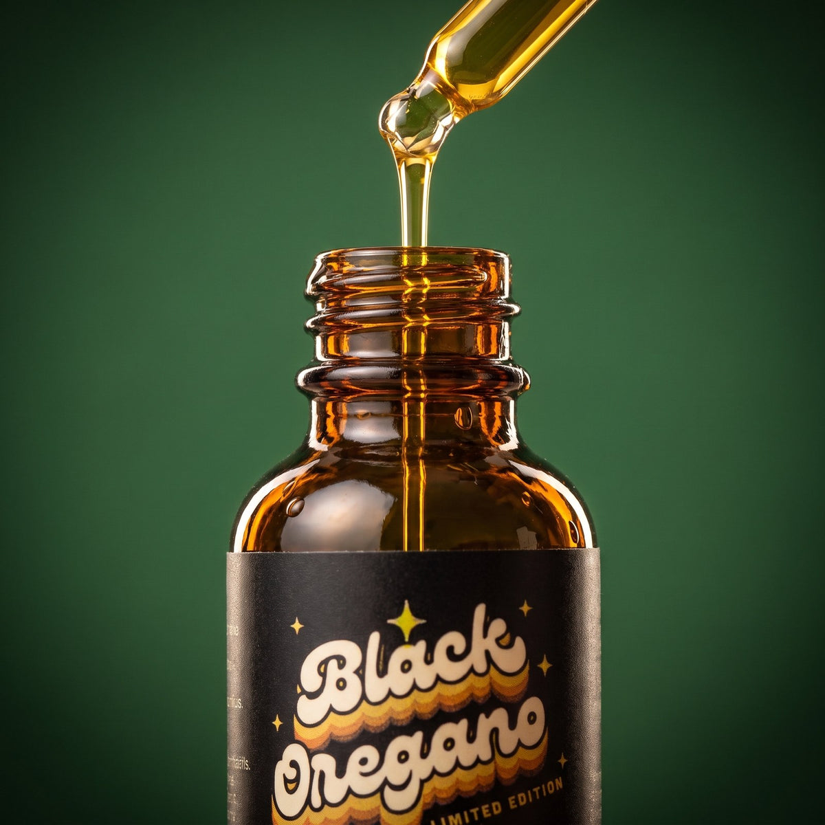 Macro close-up of the Black Oregano dropper pouring golden oil into the bottle on forest green